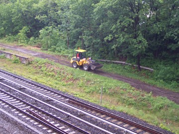 Ein Bagger planiert einen Weg entlang der S-Bahn